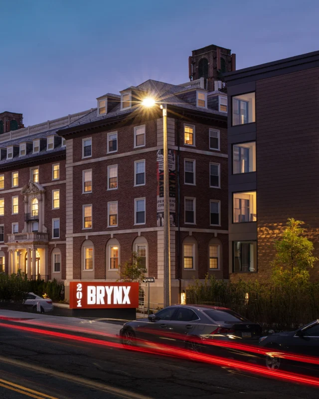 Opened in 2020, The Brynx creatively repurposed the historic 1926 Goddard House, expanding the footprint of the Georgian Revival brick building with an addition and an adjacent contemporary apartment complex. Together, the two buildings create a 149-unit multifamily development situated between Boston’s Emerald Necklace Parklands and the vibrant Jamaica Plain neighborhood. 
 
Certified LEED Gold for Homes, The Brynx seamlessly blends sustainability with design excellence. Inside, new and old, urban and parkside come together through botanical motifs, birch tree patterning, dark tones, warm wood finishes and custom interiors and amenities designed for how we live today.
 
Client partner Eden Properties / Samuels & Associates / Northwest Mutual